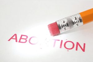 Pencil erasing the word abortion