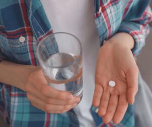 woman holding a pill in on hand